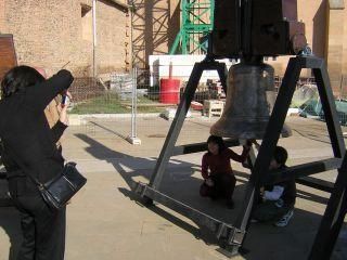 Niños fotografiándose con las campanas expuestas en la plaza