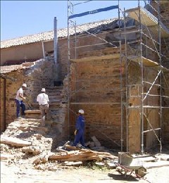 Operarios trabajando en la restauración de la iglesia de Destriana.