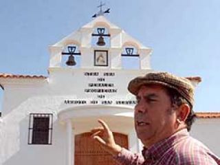 Miguel Monterrey, presidente de la Hermandad, junto a la ermita y al campanario incompleto