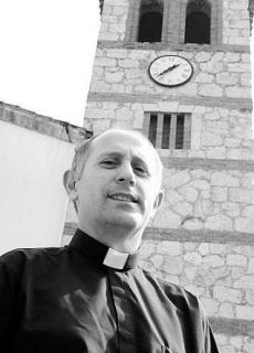 Joaquín Manuel Serrano, ante la iglesia de San Félix. Al fondo, el reloj. 