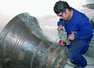 Un trabajador limpia una campana en la nave de Montehermoso en la que se fabrican
