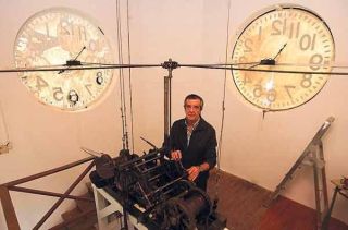 El relojero Gerardo Alonso, con el medidor de tiempo más antiguo de Vigo, que él programa
