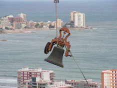 Insólita imagen de la campana “Corazón de Jesús” con la bahía de Cullera al fondo el día que se bajó para la restauración.