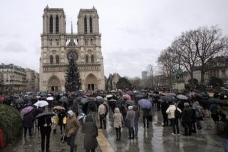 Plusieurs centaines de personnes écoutent sonner le glas en hommage au victimes de l’attentat contre Charlie Hebdo, sur le parvis de Notre-Dame de Paris, jeudi 8 janvier 2015 à 12h. - Autor: ALEXANDRE, Mathieu (AFP)