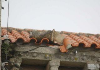 El escudo caído en el tejado sobre el canecillo de la iglesia - Autor: S. A