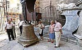 La campana El Manuel, ayer, en la entrada de la Puerta de los Hierros de la Catedral, contemplada por los transeúntes
