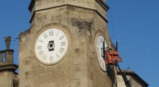 Uns operaris manipulant les busques d'un dels dos rellotges de l'església de Sant Esteve, ahir a la tarda - Autor: CARRÉ, Enric / EL PUNT