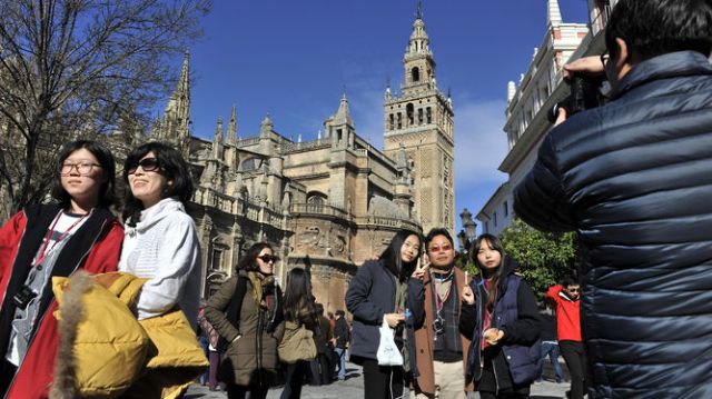 Turistas en el entorno de la Catedral, con la Giralda de fondo. - Autor: VÁZQUEZ, Juan Carlos / DIARIO DE SEVILLA