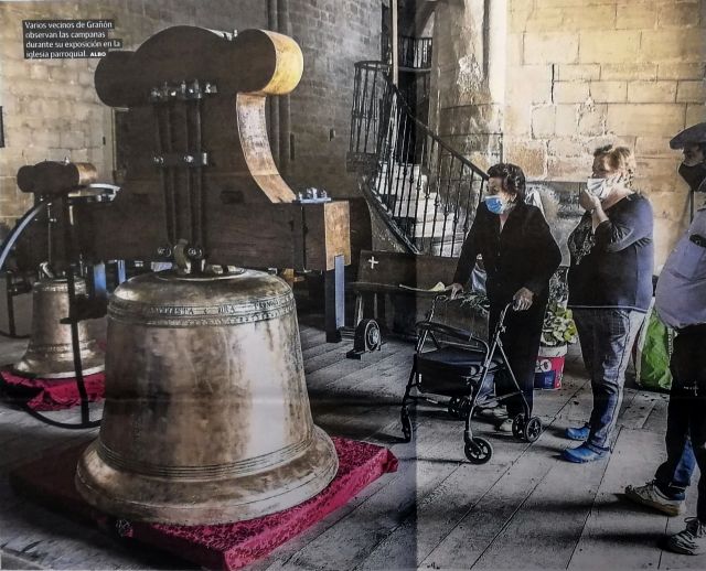 Varios vecinos de Grañón observan las campanas durante su exposición en la iglesia parroquial
