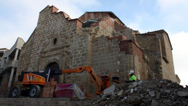 El darrer munt de runa de les restes del campanar de l'església de Rosselló i al fons un operari treballant en els treballs al davant del temple - Autor: ACN