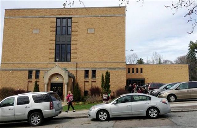 Varios padres recogen a sus hijos al final del día escolar en la escuela de la Iglesia Cristo Rey en Burlington, Vermont, en una foto del 29 de abril de 2015. Los himnos y sonido de campanas que una iglesia católica de Vermont emite electrónicamente molesta a algunos de los habitantes de un vecindario en un estado que ha sido identificado como el menos religioso del país. - Autor: RATHKE, Lisa / Foto AP