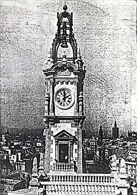 Torre del reloj en cuyo remate cuelga el carillón, que a las doce del día y de la noche hace sonar los primeros compases de la Marcha de la Ciudad merced a los diecinueve martillos que actúan sobre las siete campanas que forman aquél.